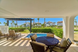 Eine Außenpatio mit Pool, Liegestühlen und einem Tisch.