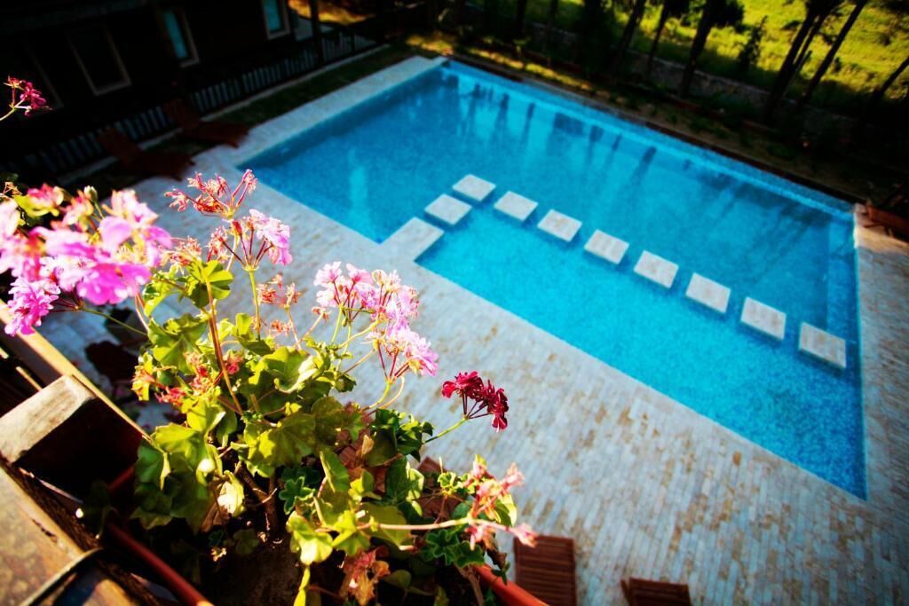 Una piscina rectangular con borde de azulejos y algunas piedras para pisar.