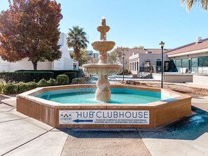 Experience the tranquil atmosphere of The HUB CLUBHOUSE at Las Palmas Resort, surrounded by lush greenery and a serene water feature.