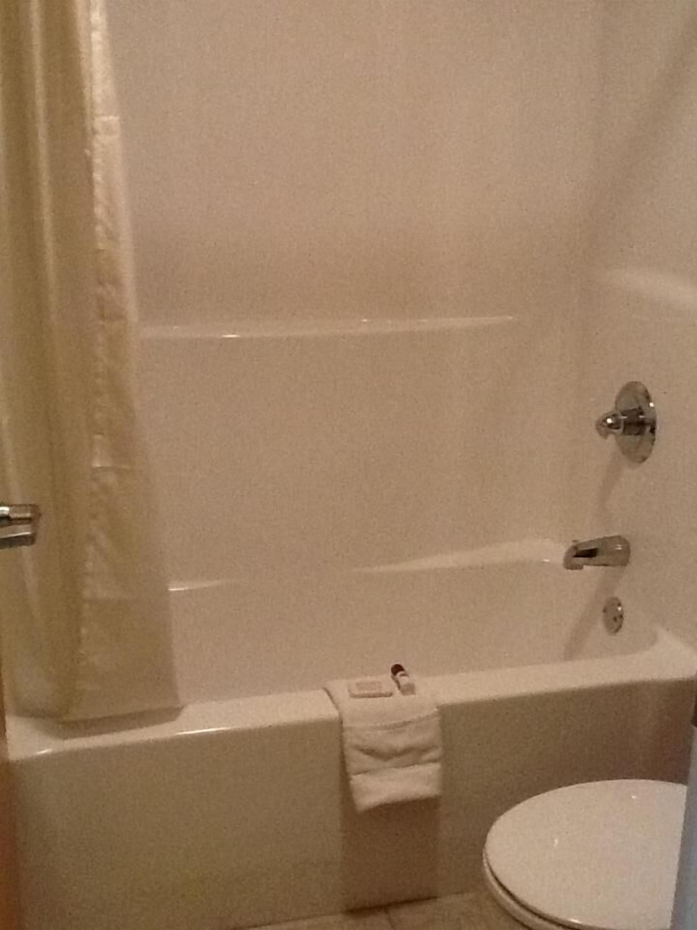 Un bagno con vasca, water e asciugamano appeso al muro.