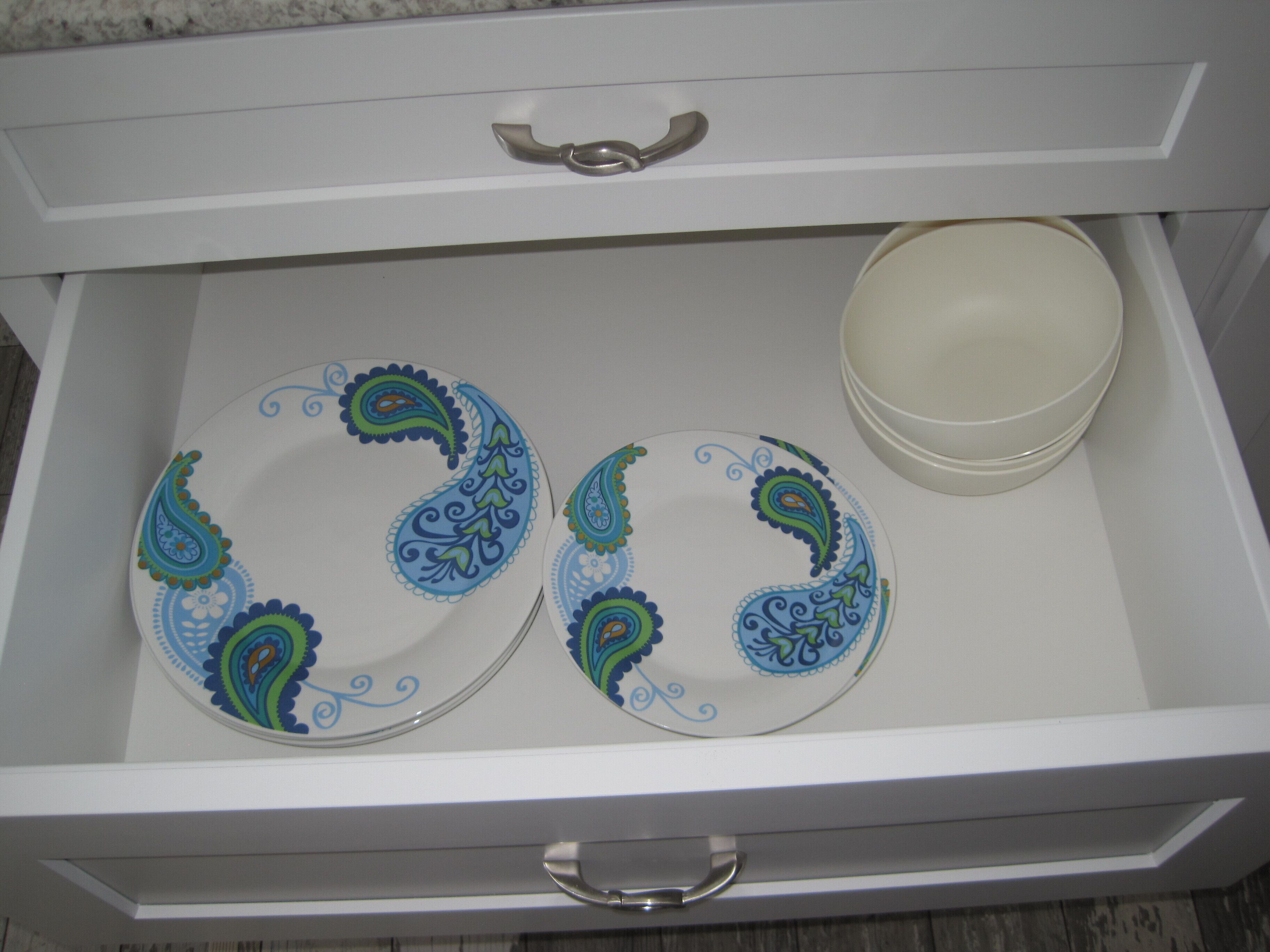 A drawer containing two decorative plates and a bowl.