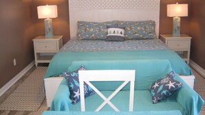 A bedroom with a bed, two bedside tables, and a nightstand. - Mermaid relaxing studio with Pool (St. Augustine)