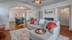 A spacious living room with a grey sofa, wooden coffee table, and a ceiling fan. - Circle Bar Manor — Spacious 4BR, Sheridan WY (Sheridan)