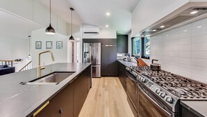 A modern kitchen with a central island, stainless steel appliances, and a view to the outdoors.