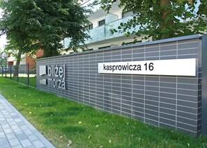 Un bâtiment sur lequel on peut lire les inscriptions « blizej morza » et « Kasprowicza 16 ».
