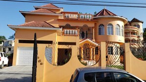 Una casa a più piani con garage, balcone e un cancello decorativo.