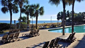 A poolside area with lounge chairs and a view of the beach. - Beautiful Clean Modern Direct Oceanfront Unit With Amazing Views (Myrtle Beach)