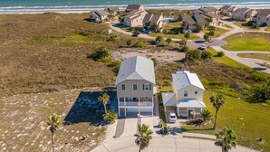 Uma área residencial costeira com casas, uma praia e uma vista clara do oceano.