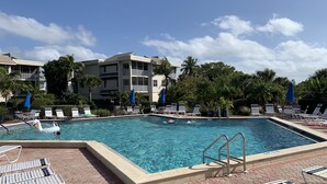 A swimming pool with lounge chairs and umbrellas, surrounded by multi-story buildings with balconies. - Wonderful Sanibel Island condo. 2 bed 2 bath. Sleeps 6. Weekly rental.  (Sanibel)