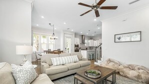 Un salon avec un canapé, une table basse et un ventilateur de plafond.