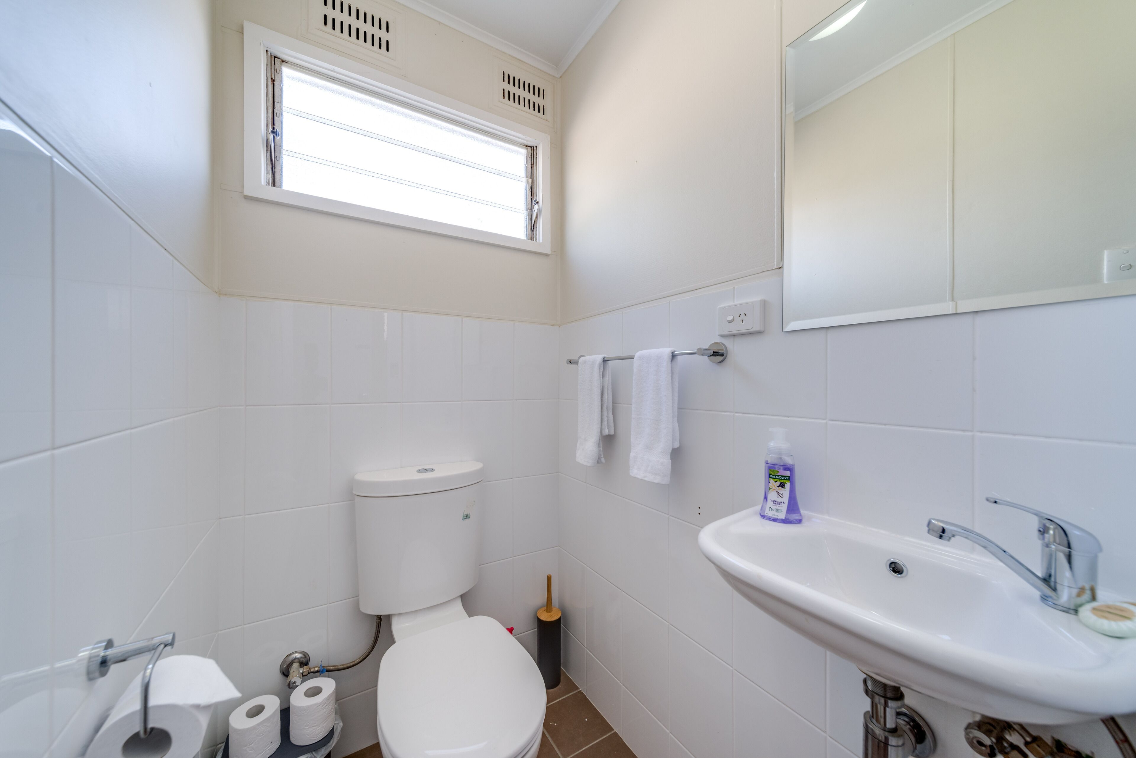 Ein Badezimmer mit Toilette, Waschbecken und Fenster.