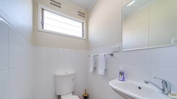 Ein Badezimmer mit Toilette, Waschbecken und Fenster.