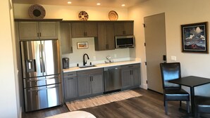 A compact kitchen with a refrigerator, microwave, and sink.