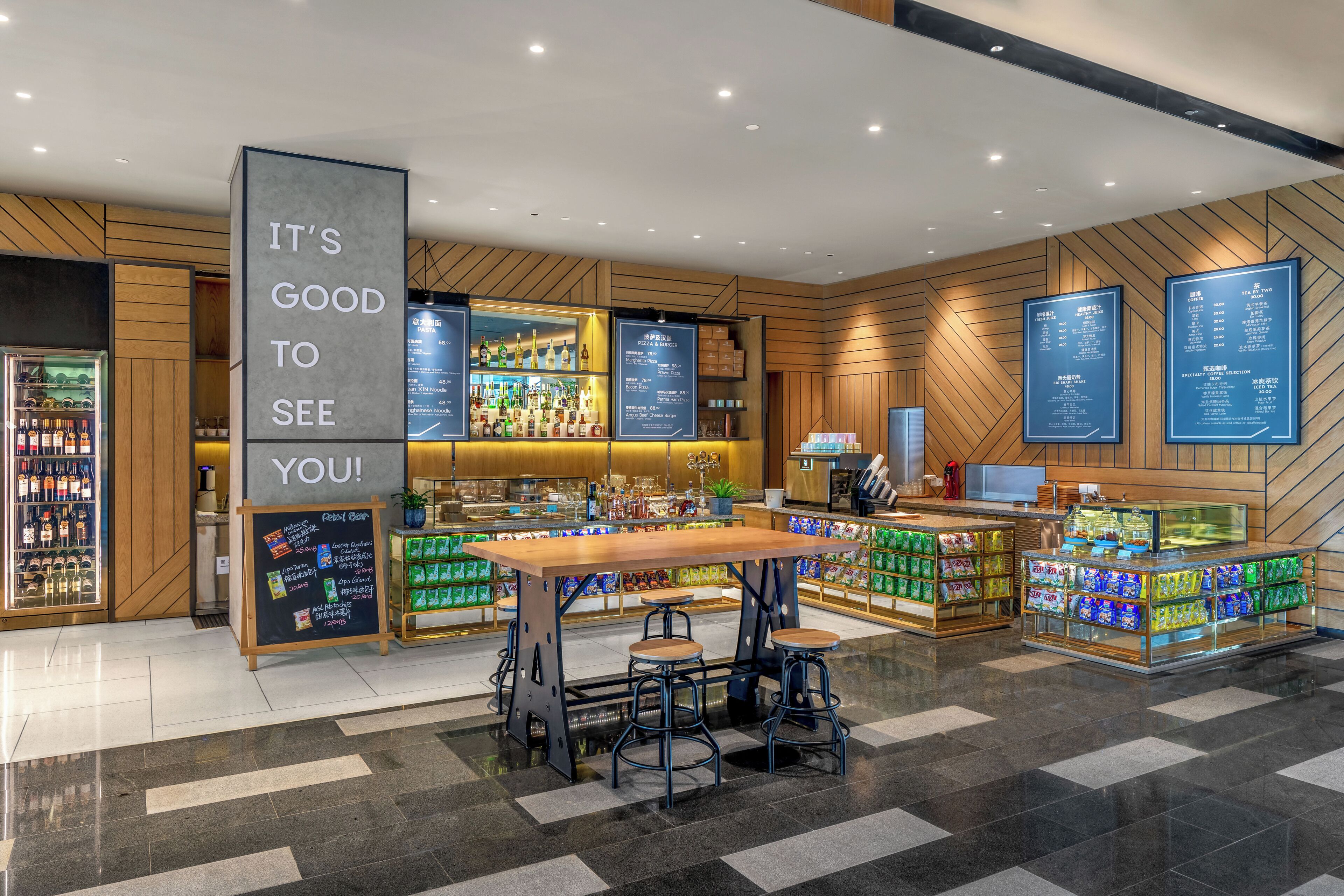 Un espace bar moderne avec un comptoir en bois, des tabourets et un tableau affichant le menu.