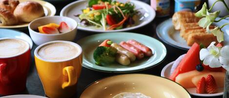 A variety of dishes, including a plate with a fried egg, a bowl of salad, and several other plates with different foods.