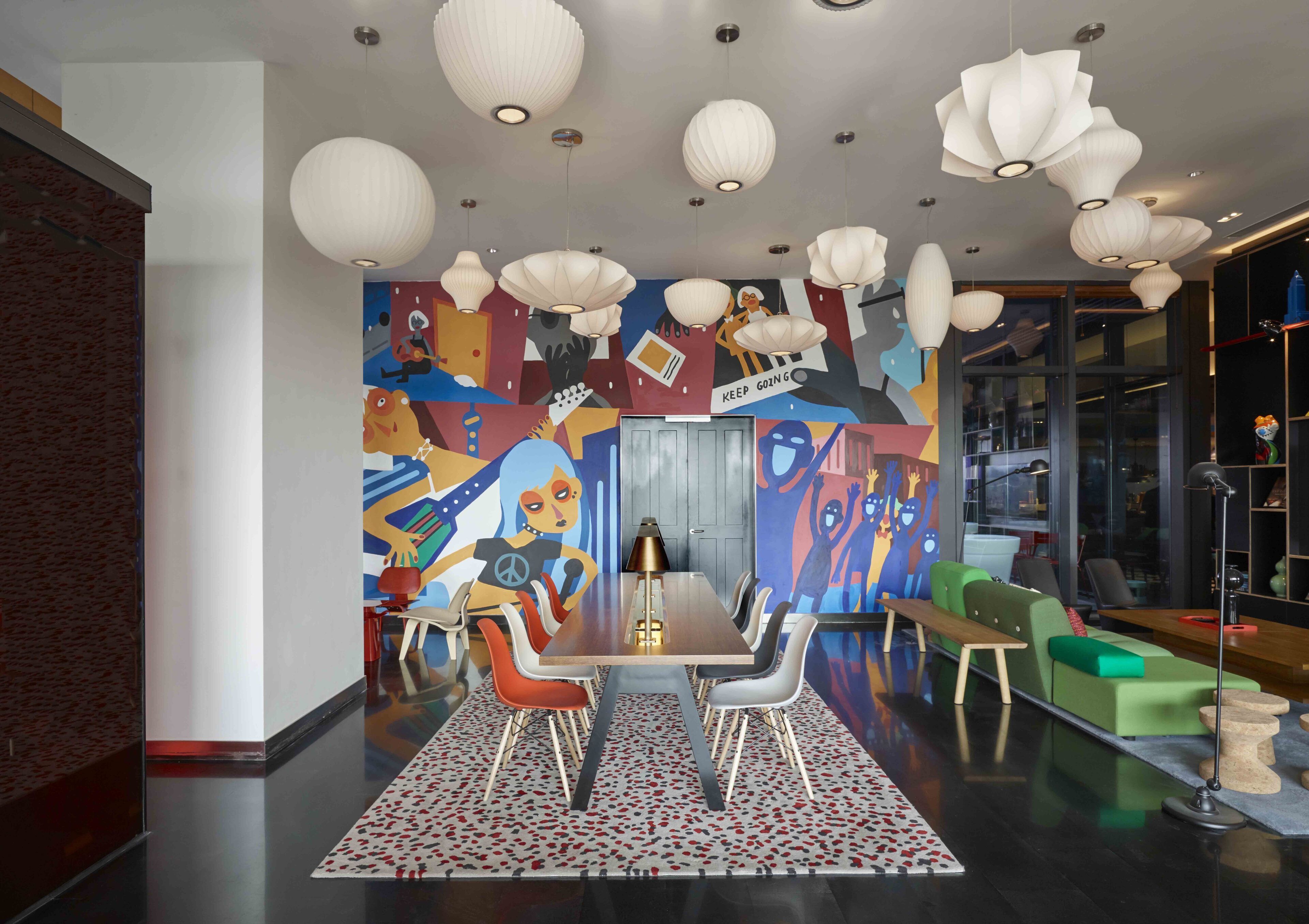 Un espace de restauration moderne agrémenté d’une fresque murale, d’un éclairage original et de mobilier contemporain.