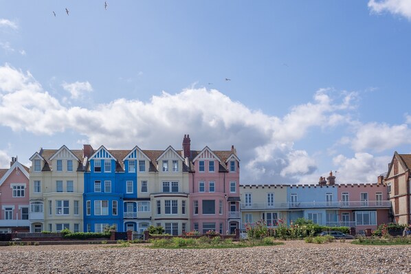 A row of colorful houses with a clear sky and some clouds. - Alexander House, Thorpeness (Leiston)