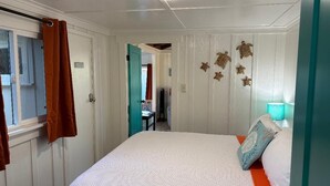 A bedroom with a bed, a window with curtains, a door, and wall decorations. - Walk to Embarcadero + Kids Dream Yard + Pool Table (Morro Bay)