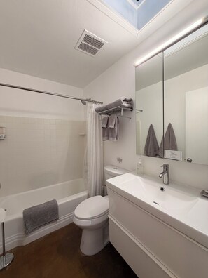 A modern bathroom with a bathtub, toilet, and sink. - 2BR Pet-Friendly Condo, Walkable Location (Phoenix)