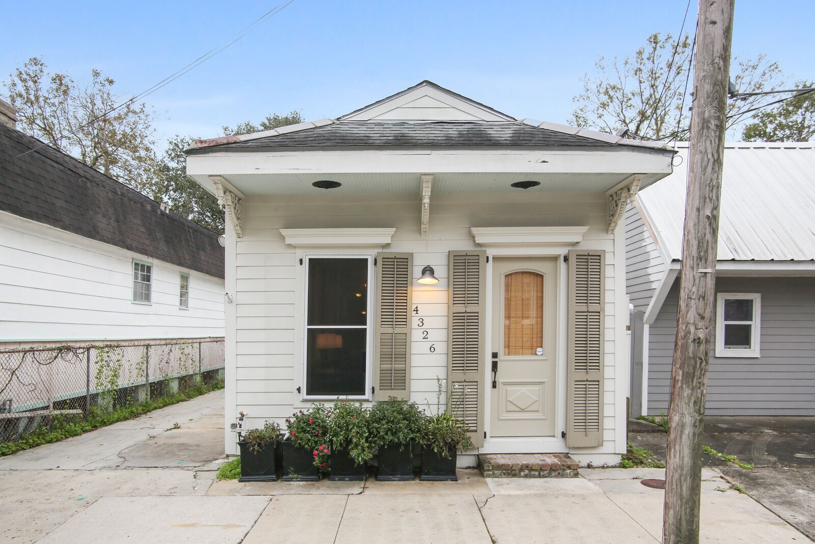 A small, single-story house with a front porch, a mailbox, and a number '4' on the door.