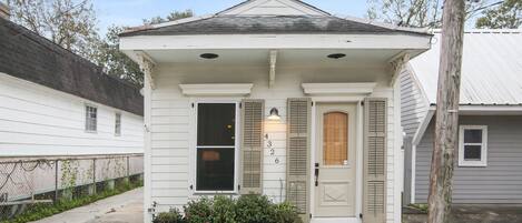 A small, single-story house with a front porch, a mailbox, and a number '4' on the door.