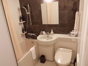 Un baño moderno con bañera, lavamanos e inodoro. Se observa un cabezal de ducha, un perchero y un dispensador de jabón.