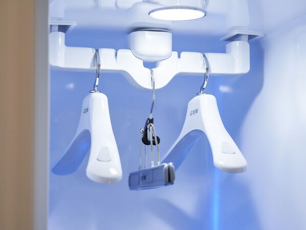 Una lámpara moderna de techo blanca con un mando central y dos brazos ajustables.
