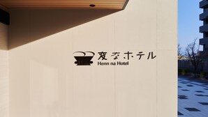Un letrero de hotel con caracteres japoneses y el texto en inglés 'Henn na Hotel'.