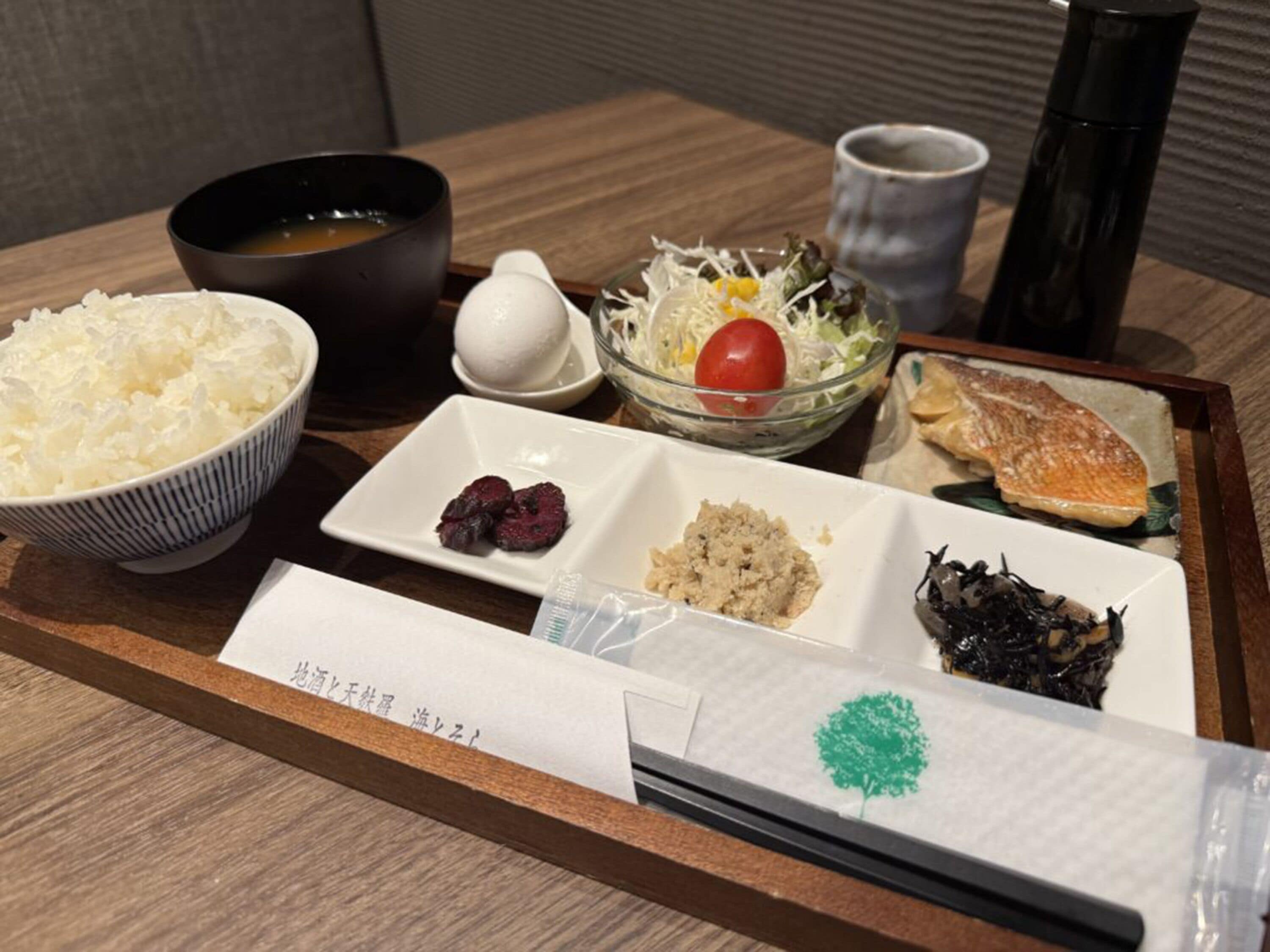 Un plateau contenant divers plats japonais, notamment du riz, du poisson et des légumes.