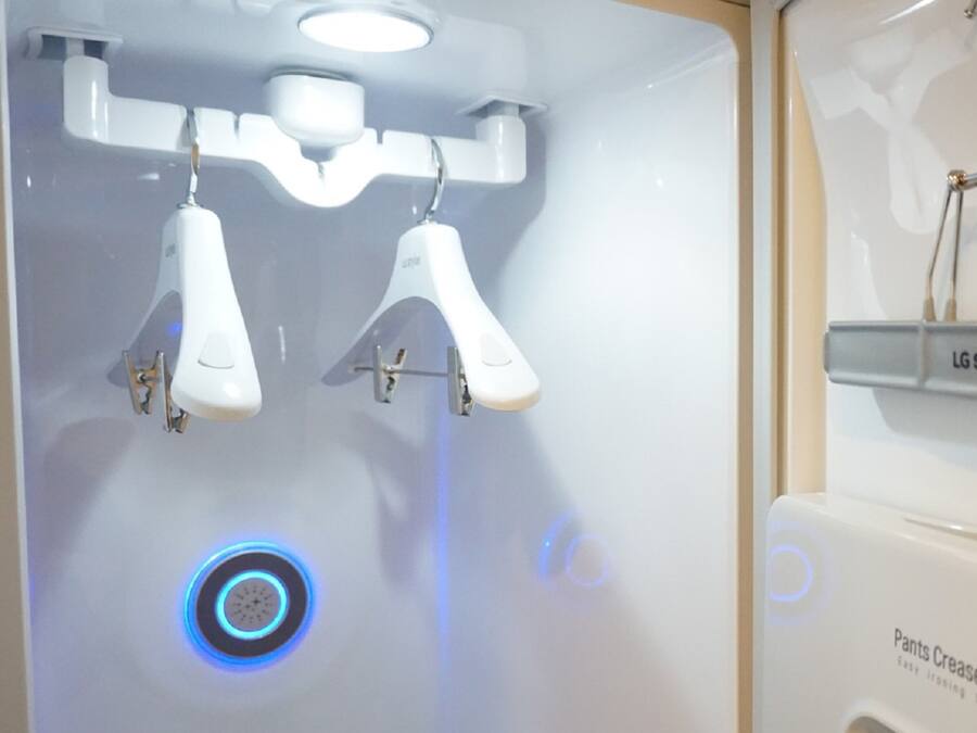 A bathroom with a modern design, featuring a sink with a mirror and a wall-mounted faucet.