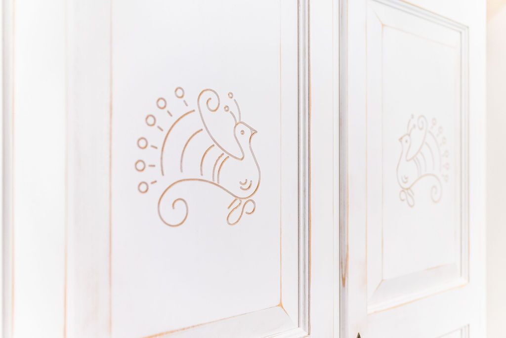 A door with a simple line drawing of a bird and a peacock.