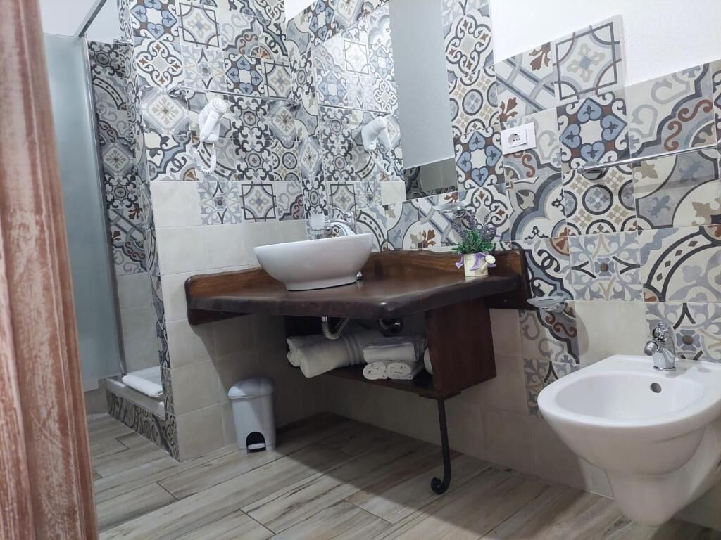 Une salle de bain avec un lavabo, un bidet et des murs carrelés.