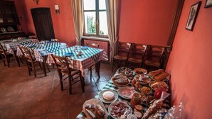 A dining area with multiple tables set with checkered tablecloths, wooden chairs, and a variety of food items. - Room in B&B - Agriturismo Al Brich Triple With Breakfast (Albaretto della Torre)