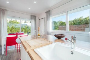 Een moderne keuken met een groot raam, een houten aanrecht en een spoelbak.