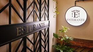 A sign with the name "ESTERANTE" and a circular logo with "EL" and "RESTAURACJA" on a wall. - Hotel Estera (Kraków)