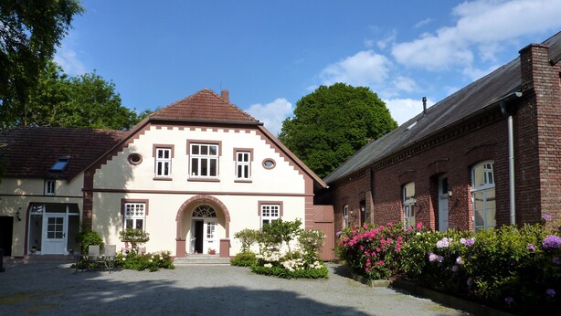 A building with a symmetrical facade, a central entrance with an arch, and a gravel driveway. - Landhaus Wattmuschelfewo Samtmuschel, Romantic Property in a Secluded Location, (Jaderaltendeich)
