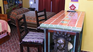 Une pièce comprenant un lit, une chaise, une table et un élément décoratif mural.