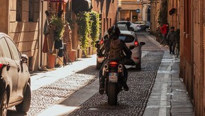A narrow street lined with historic buildings, a vintage shop, and parked cars.