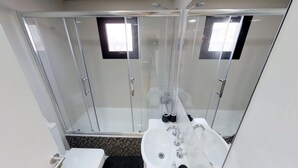 A modern bathroom with a glass-enclosed shower, a white sink, and a toilet. - New Studio Fully Furnished, Near Everything (Buenos Aires)