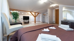 A modern hotel room with a large bed, a desk with a computer, a TV, and a bathroom with a shower and a mirror. - Room in B&B - Valensija - Suite for two With Balcony #1 (Jurmala)