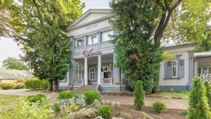 A large, historic building with a central porch and columns, surrounded by mature trees and well-maintained landscaping. - Room in Guest Room - Valensija - Standard Twin Room (Jurmala)