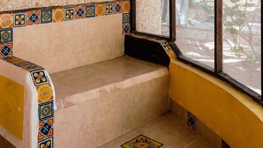 A room with a window, a woven ceiling light, a tiled bench, and a patterned tile border. - Room-antigua Lodge, Away From the Crowds (El Cuyo)