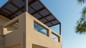 A modern two-story house with a balcony, stone walls, and a swimming pool area. - Palladio Villa Roussospiti (Rethymno)