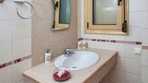 A bathroom with a white sink, a mirror, and a towel rack. - Palladio Villa Roussospiti (Rethymno)