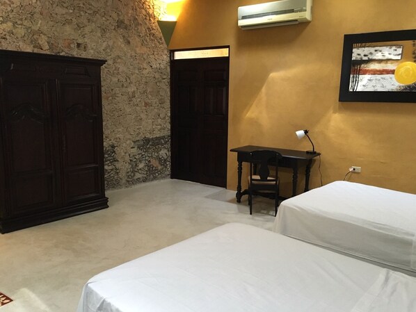 A room with two beds, a desk, and a wardrobe. - Merida Casa Colonial Centro Suite (Mérida)