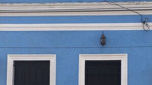 Un edificio con dos puertas negras y una pequeña luminaria encima.