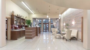 Eine moderne Hotelhalle mit Empfangstresen, Sitzgelegenheiten und einer dekorativen Wand.