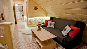 A cozy wooden interior with a sofa, pillows, and a small table.
