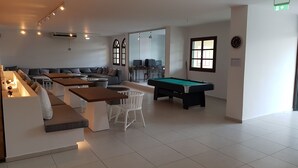 Una sala de estar moderna con mesa de billar, sofá y zona de bar.