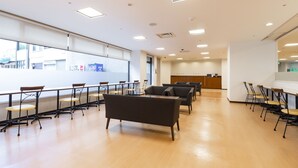 A spacious room with a long table and chairs, a sofa, and a reception desk. - The OneFive Okayama (Okayama)